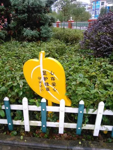 修剪整齐的花木中随处可见设计精巧的爱护花草的提示牌.