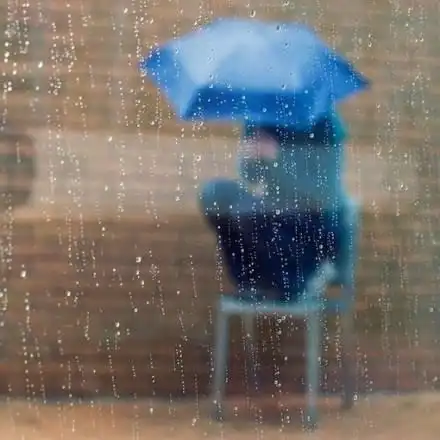 撑一把雨伞在雨中漫步的图片