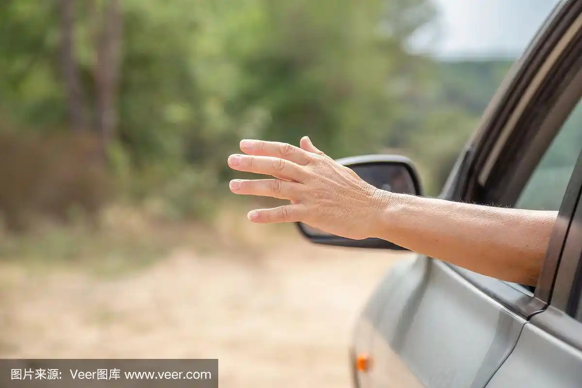 女性的手从车的左车窗伸出来