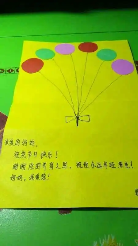 这位小朋友亲手自制一张贺卡给母亲送给妈妈一份温暖.