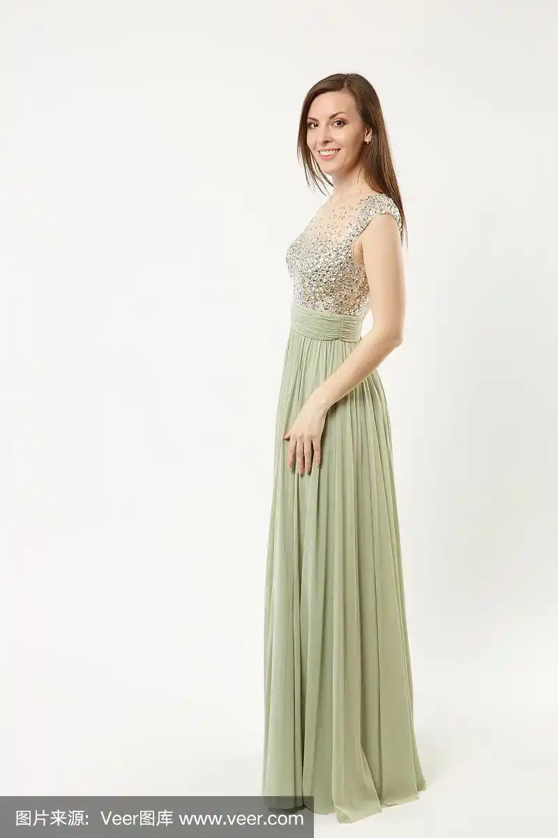 全身照片时装模特女人穿着优雅的晚礼服橄榄礼服摆姿势孤立在白墙背景