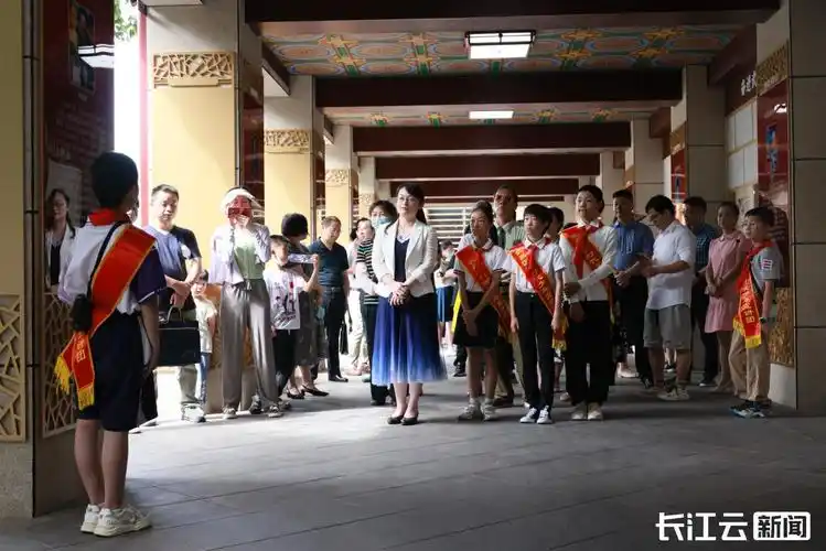 少年宣讲员和其他游客一起制作文明油纸伞,书写文明标语,为"七一"建党