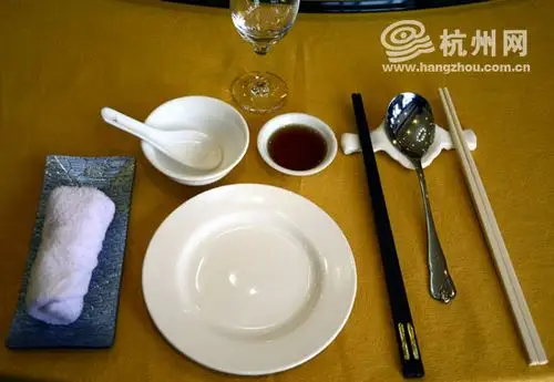 双筷制的餐具摆放样式,白筷为取食筷,黑筷为进食筷.