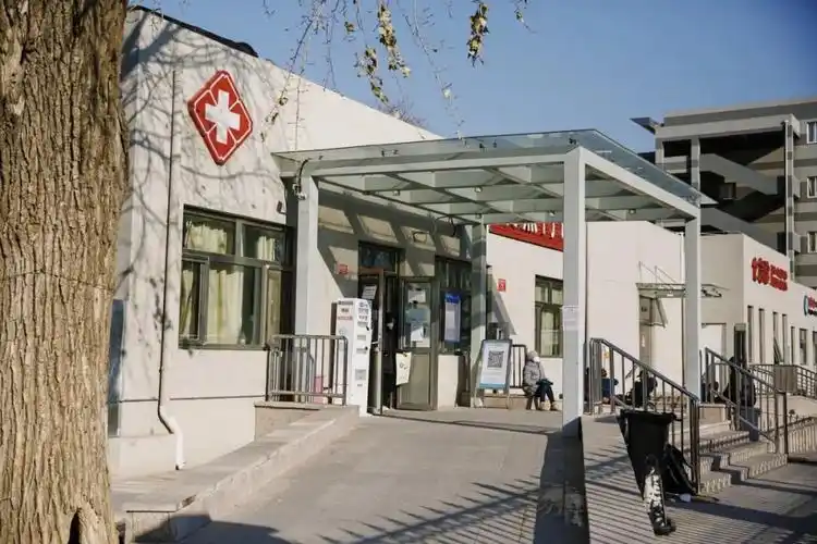 2022年12月31日,北京大学首钢医院发热门诊,女子在门诊前沐浴阳光.
