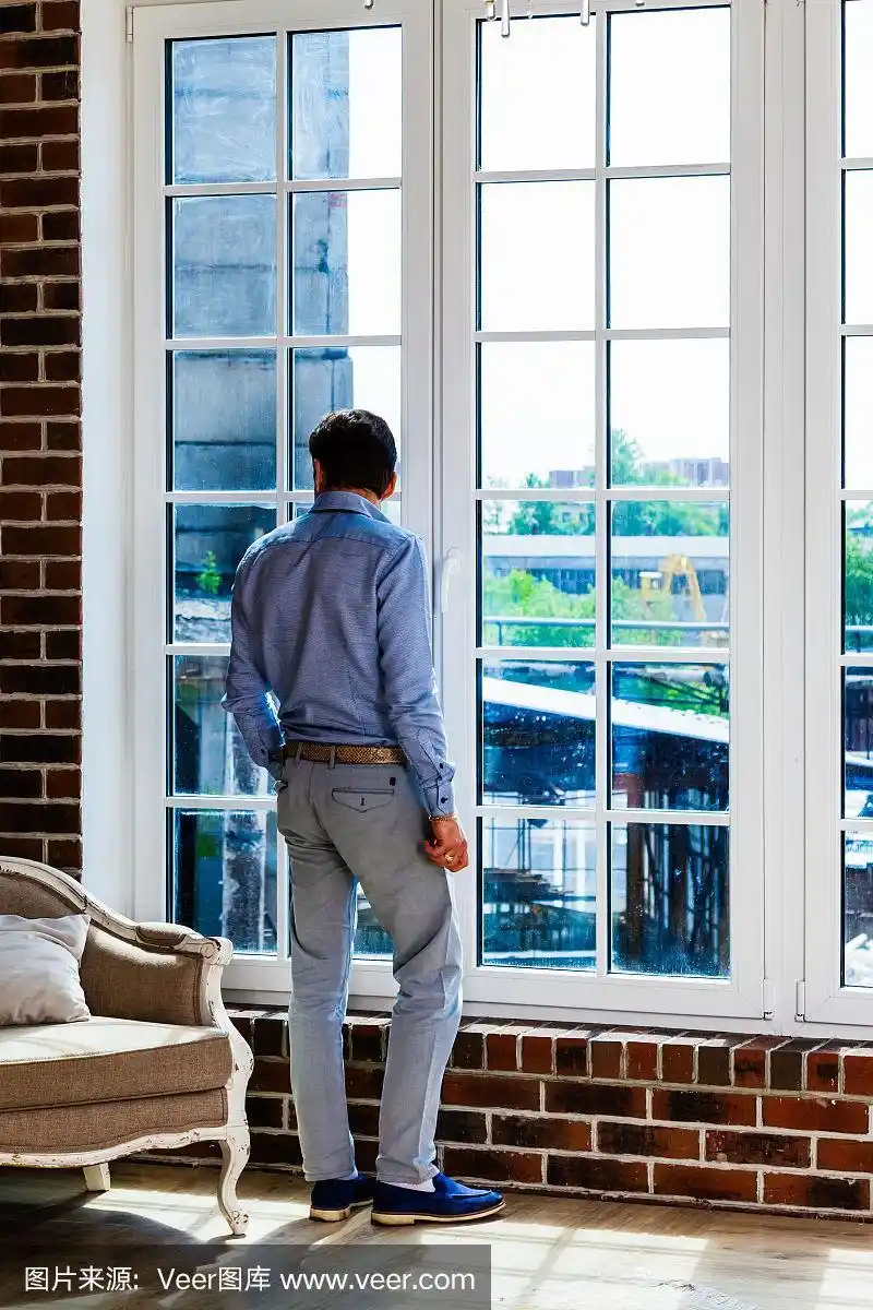 一个男人站在窗前的画像
