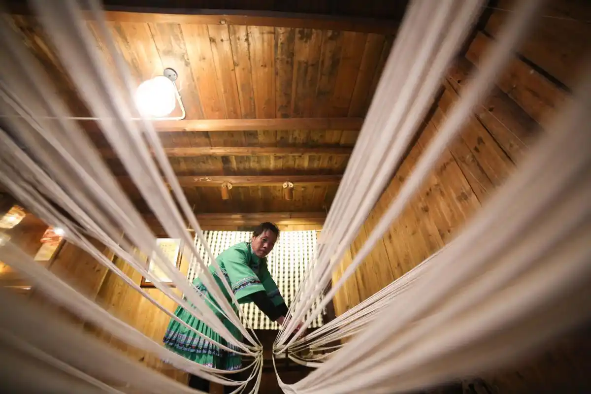 日,在贵州省铜仁市玉屏侗族自治县新店镇老寨村,一名侗族妇女准备织布