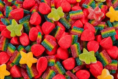 果冻糖.柑桔片果冻candyies 在黄色背景不同形状,颜色和大小的糖果