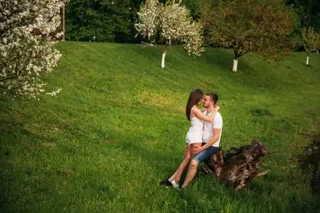 在公园约会.爱的情侣站在草地上, 靠近湖边.浪漫与爱情照片