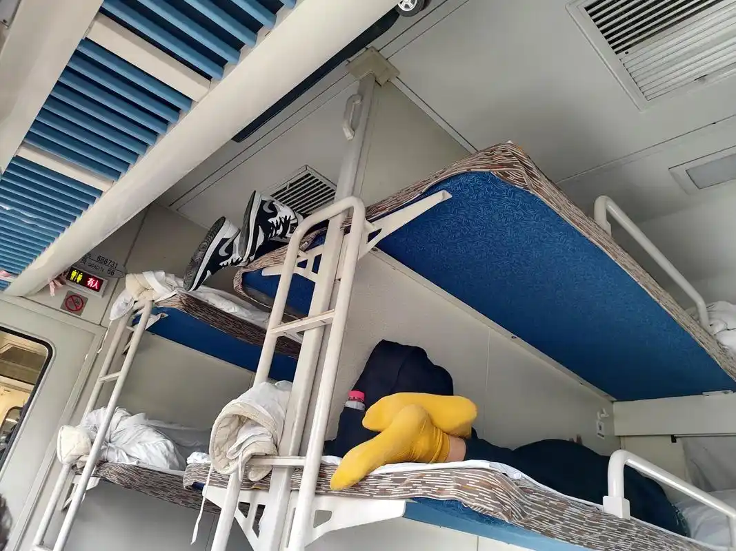 我的卧铺是中铺,上铺的小伙子穿着鞋子爬到上铺,并且把穿着鞋子的脚