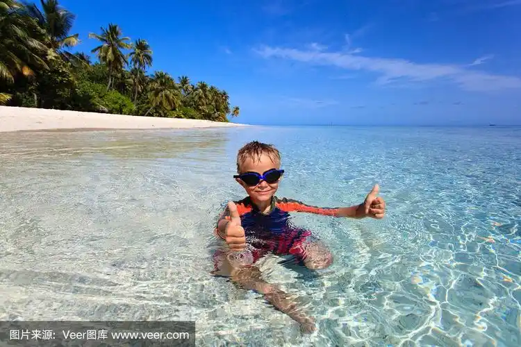 快乐的小男孩在热带海滩游泳