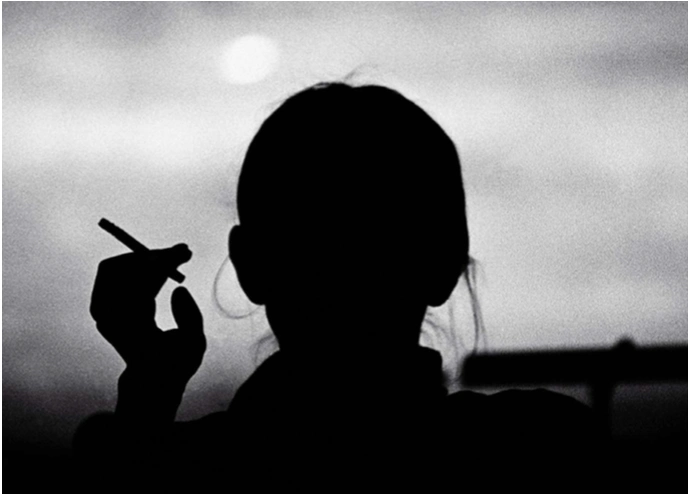 总是一身黑衣,一头深色长发绑成马尾,手里夹着一根烟.