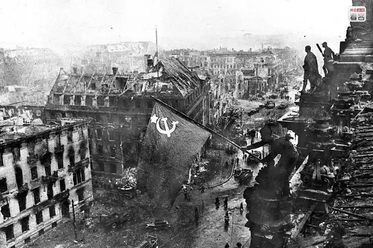 图为1945年5月2日,德国柏林,一名苏联士兵将红旗插在德国国会大厦上.