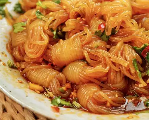 魔芋丝滤干水分,与黄瓜丝,胡萝卜丝放入盘中 加入蒜蓉,辣椒酱,酱油,醋