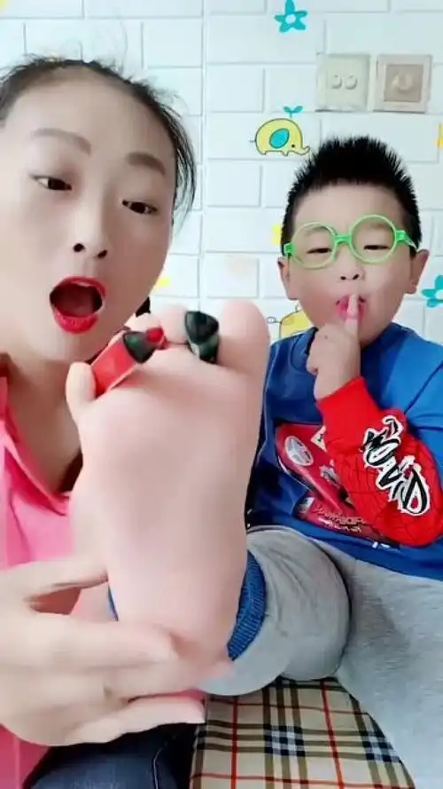 妈妈用彩笔在儿子的脚板上画画