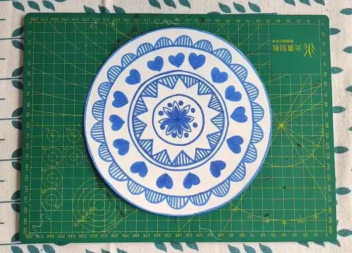 在白色素描纸上画出青花瓷盘子图案.