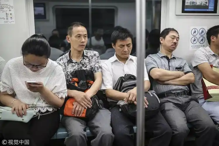 身处大都市,很多上班族都带着睡意乘坐早班地铁/视觉中国