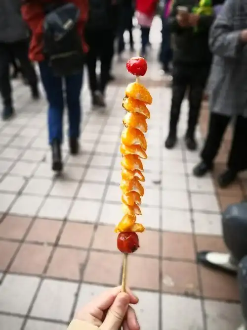 喝完咖啡,我走进了王府井的小吃街,来上一串橘子冰糖葫芦,沁凉的口味