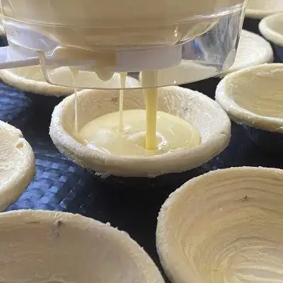 6,接着把搅拌均匀的蛋挞水倒入分液器.