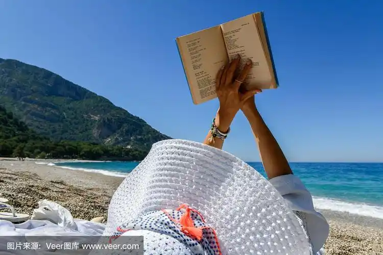 一个在海滩上看书的女人.