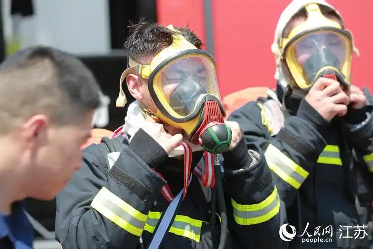 结束演练任务后,消防员准备取下防护面罩.人民网  冷金明摄