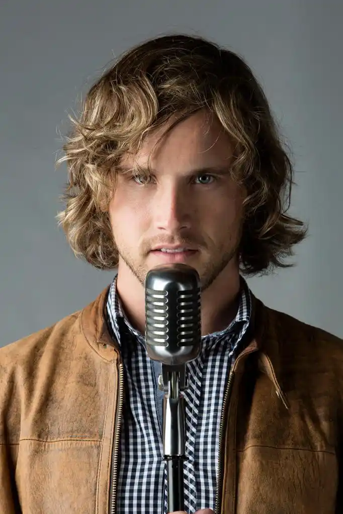 英俊的白种男人,英俊的白种人男歌手,身穿蓝色格仔颗纽扣的衬衫和一件