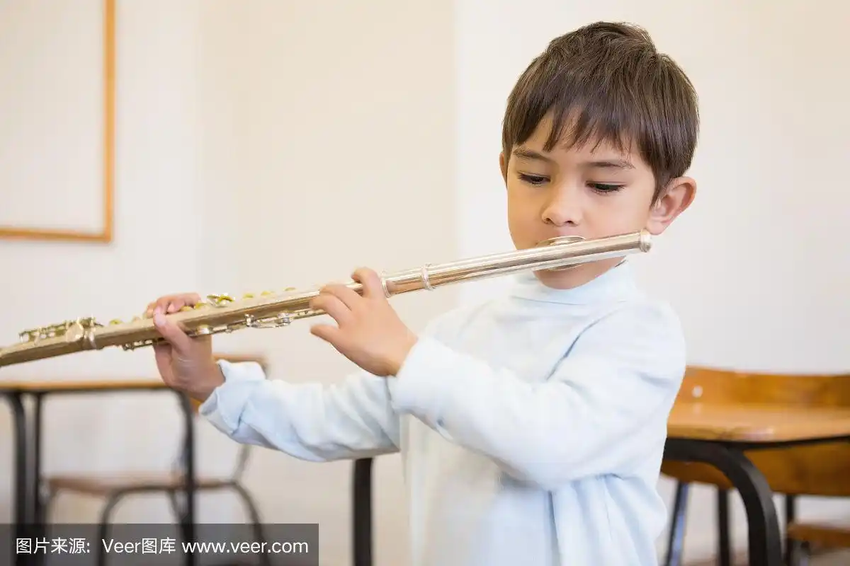 可爱的小学生在教室里吹长笛