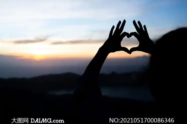 傍晚心形手势剪影摄影图片