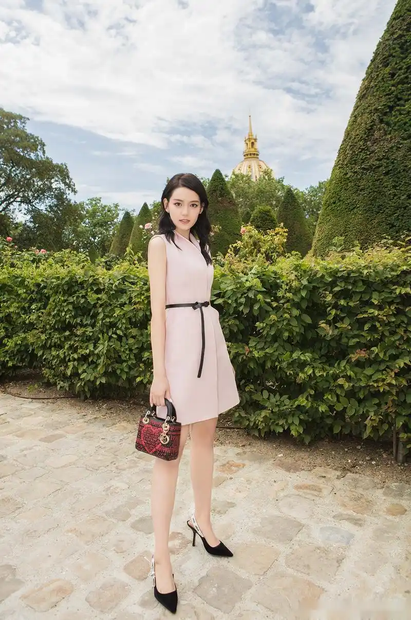 李诗颖一袭藕粉色连衣裙亮相,黑色细腰带勾勒腰线,小v衬衫领尽显突出