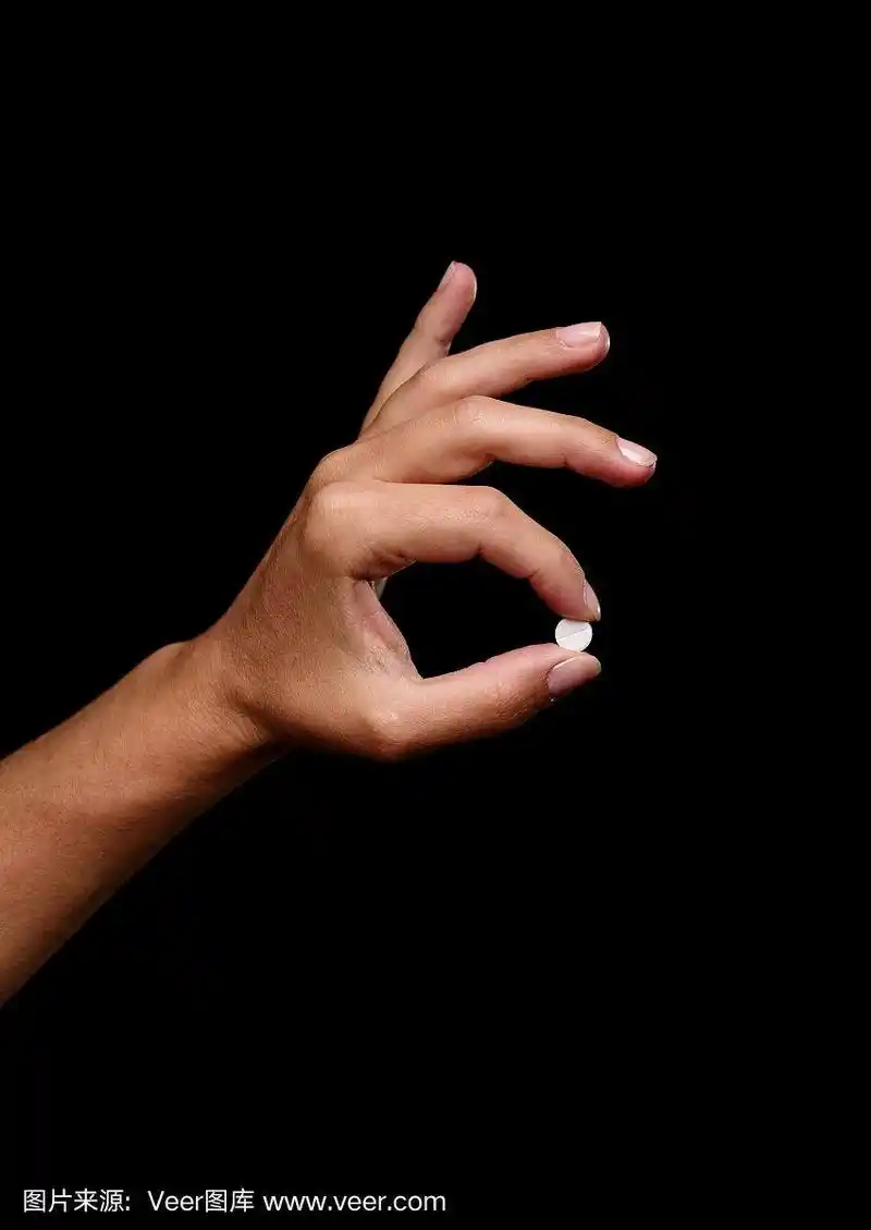 在黑色背景上拿着一颗药丸.处方药物白色片剂.医疗保健和治疗理念.
