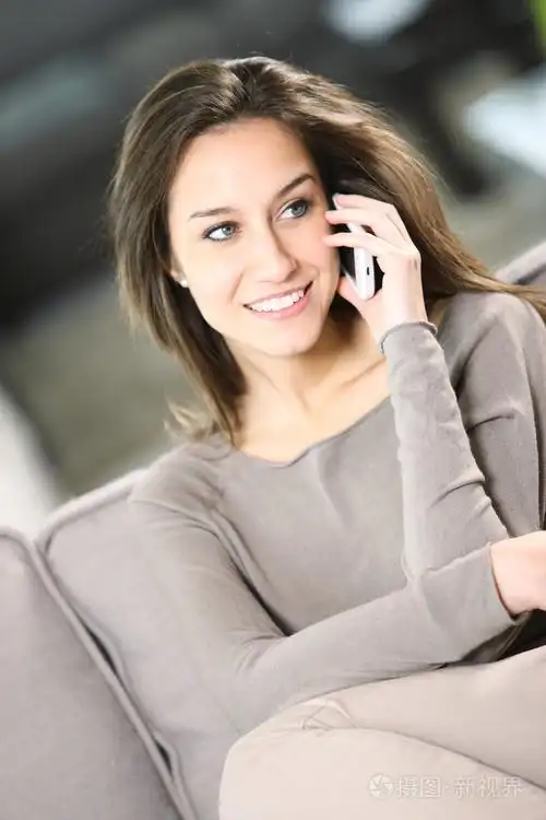 年轻有魅力的女人在家里打电话聊天