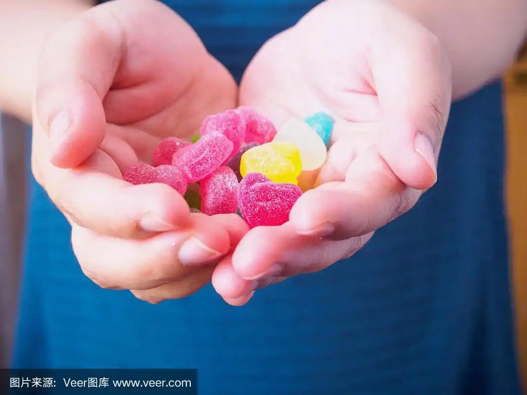 五彩心形糖果在女人的手上为情人节的背景