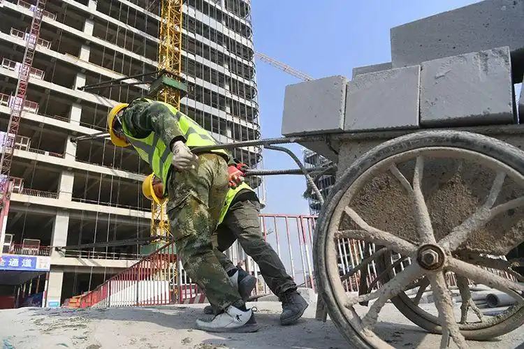 施工人员正在向楼内搬运建筑材料.新京报记者 王颖 摄