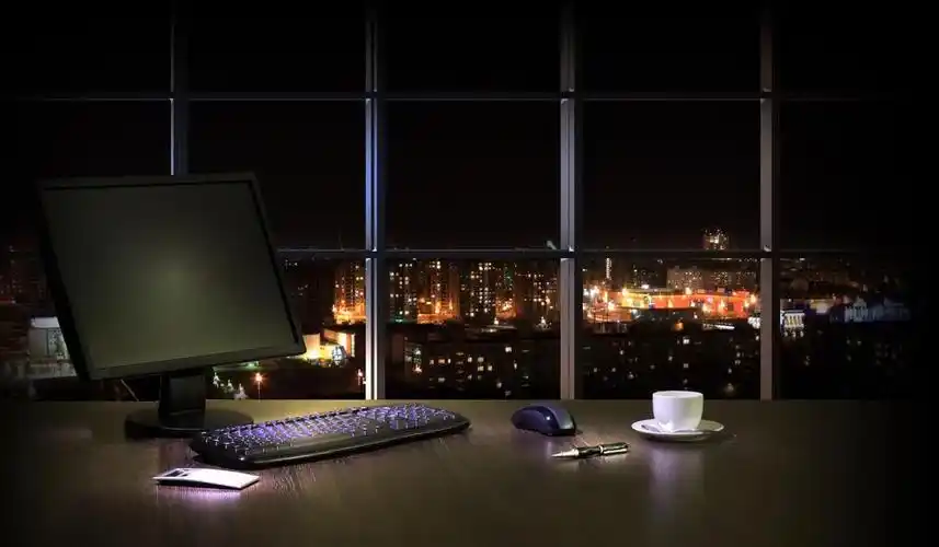 在晚上的办公室,在晚上与城市视图窗口从办公室中工作地点