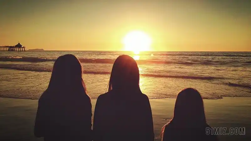 黄黑人物安静看着海面落日的三个女孩背影旅游黄昏大海背景图片