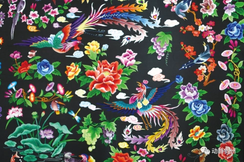 她身上这件点缀着苗绣"鸽子花"的民族服装,是她的家乡铜仁市松桃苗族