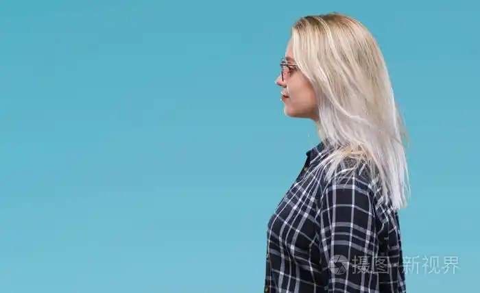 年轻的金发女人戴着太阳镜,在孤立的背景上,看着侧面放松的轮廓,自然