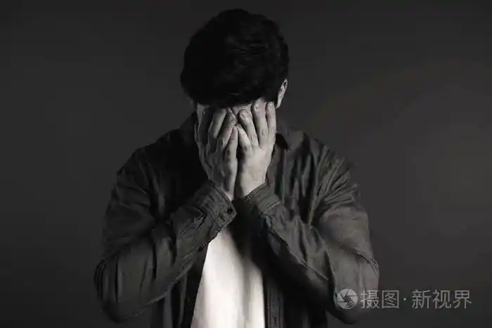 年轻人用手捂住脸以免失望失败失落的穿衬衫的男人戏剧情感概念黑白