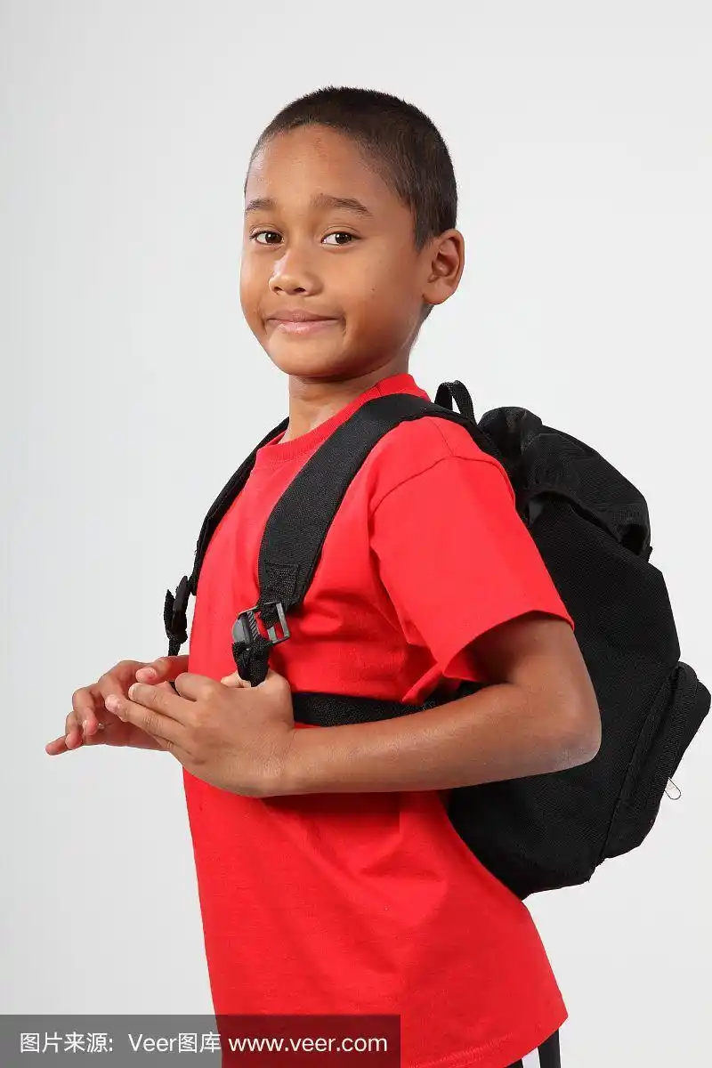 小男孩准备背着书包去上学