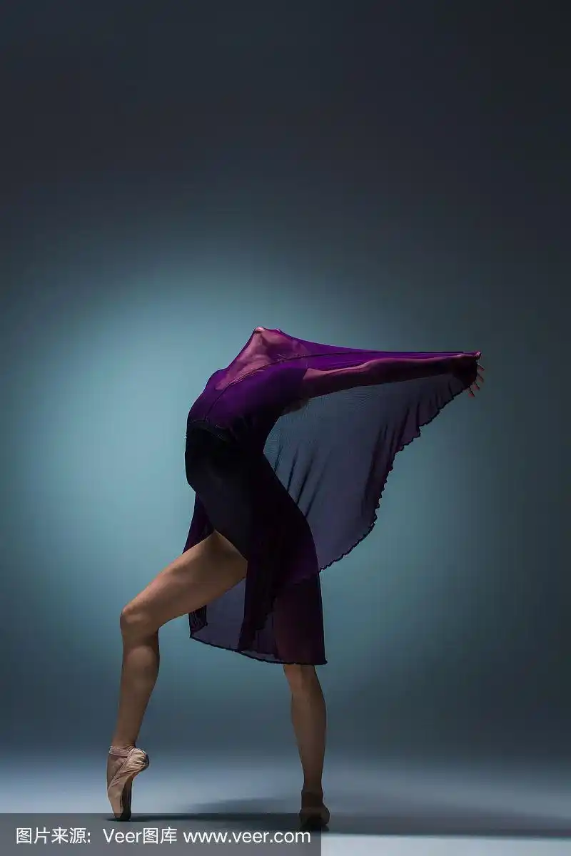 年轻美丽的现代风格舞者摆姿势在一个工作室的背景