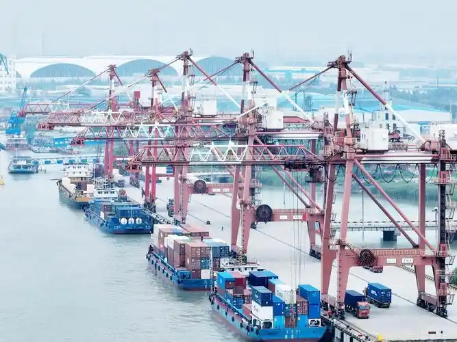 6月4日,货轮在扬州港集装箱码头的泊位上有序装卸集装箱,卡车在堆场