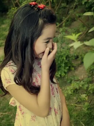 捂嘴笑的小女孩