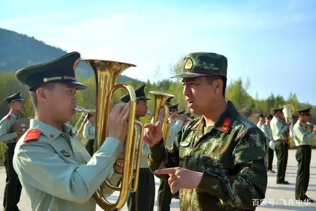 乐队指挥甄庆亮在向中音号手维康传授经验