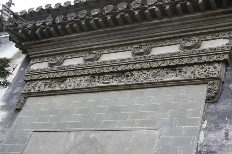 这幢"门头"上的砖雕雕的是"九世同堂"可知主人期望的是他的后人都能"