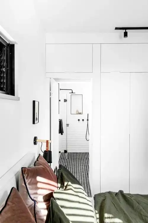 极简的衣柜,靠里侧的柜门是通往主人卫生间的隐形门,极简的设计