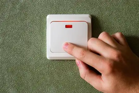 男子随手关灯节约能源照片