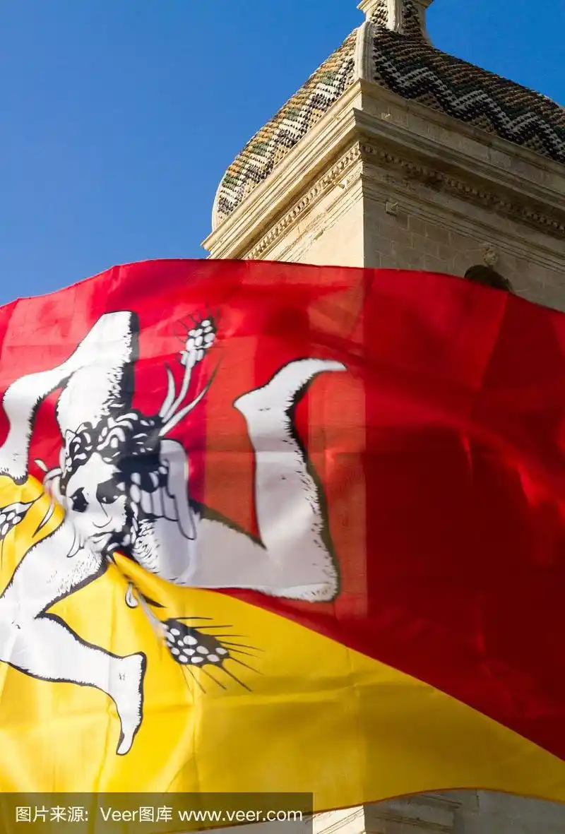 蓝天和巴洛克钟楼映衬下的西西里岛旗帜