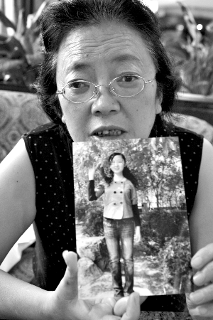 死者母亲向记者展示女儿生前的照片.