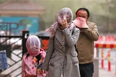 昨日下午,朝阳区豆各庄,行人将纱巾裹在头上防沙尘.