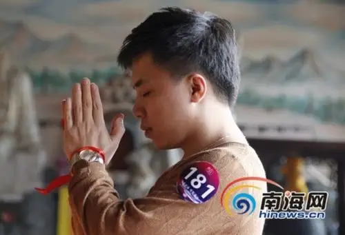 男青年在拜佛许愿.(南海网记者税博摄)
