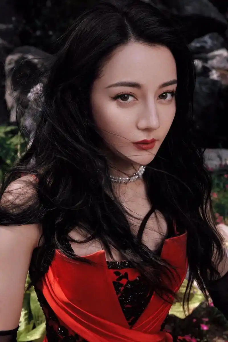 迪丽热巴的一组美照曝光,她身穿红黑色吊带礼服置身山水之间,戴 - 抖